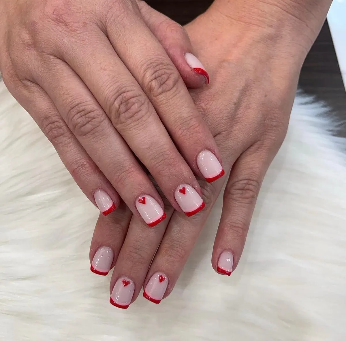 Short square nails with red French tips and tiny red hearts